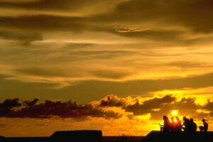 The most lovely sunset ever caught on film and a group of people chatting in front of it
